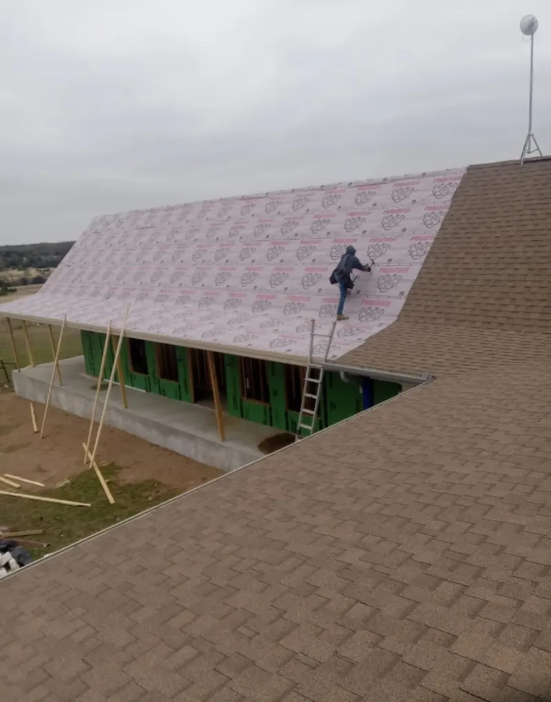 Worker preparing underlayment for a metal roof installation in Point Pleasant Beach